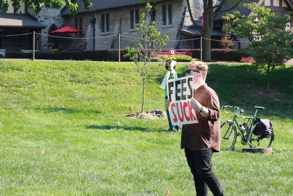 <p>A protester holds a sign that says “Fees suck” during a protest Aug. 24, 2020, in Dunn Meadow. Eight members of the Indiana Graduate Workers Coalition filed a discrimination complaint against IU through the Equal Employment Opportunities Commission, according to a press release. </p>