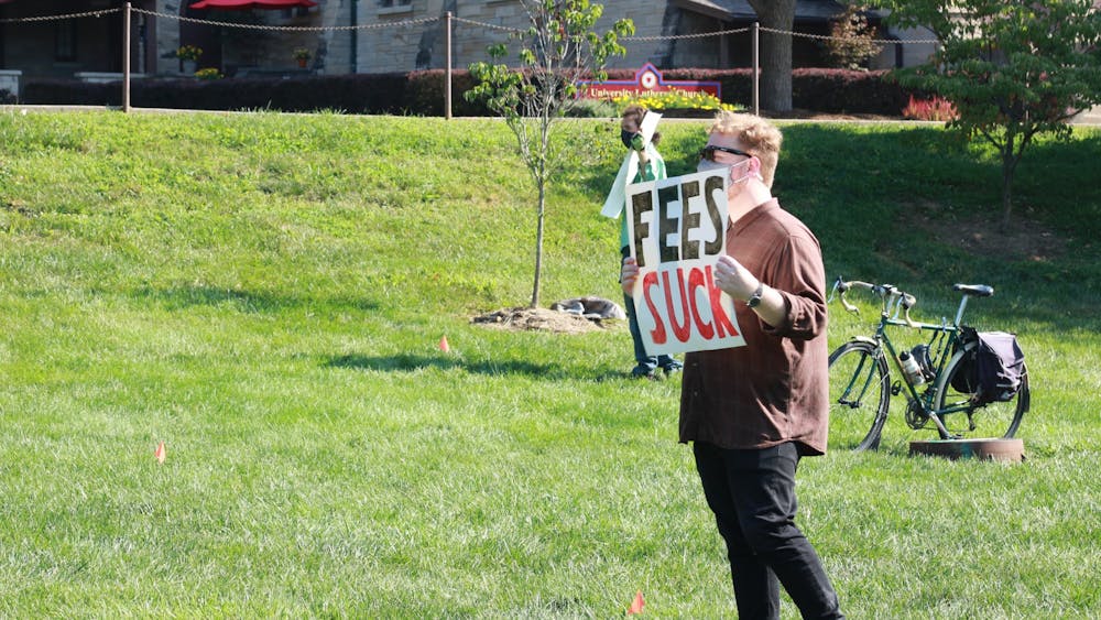 2020年8月24日，在邓恩梅多的一场抗议活动中，一名抗议者举着一个牌子，上面写着“费用糟透了”。据一份新闻稿称，印第安纳大学毕业生工人联盟(Indiana Graduate Workers Coalition)的八名成员通过平等就业机会委员会(Equal Employment Opportunities Commission)对印第安纳大学提出了歧视投诉。