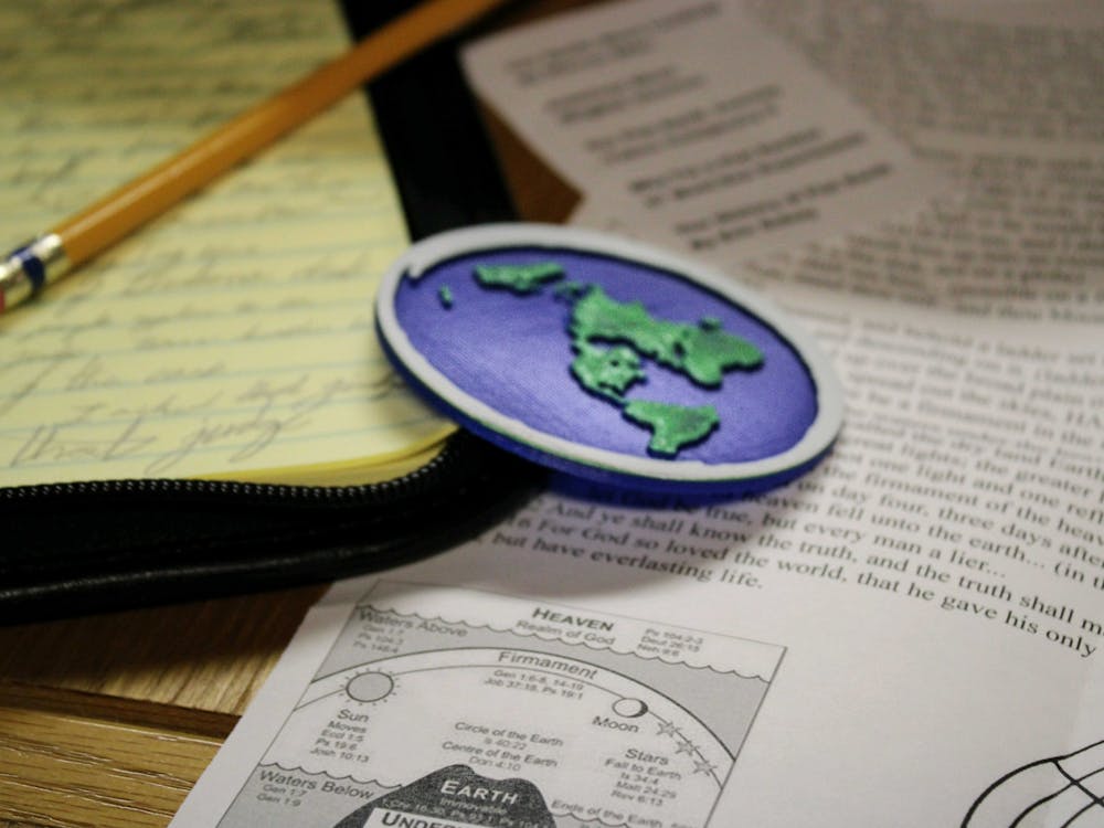 A 3D printed flat earth model lies on pieces of papers on Oct. 5, 2021, at Wright Quad.