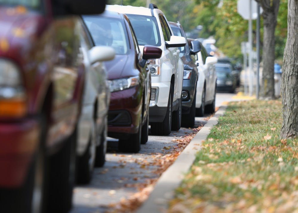 Parked cars are lined up against the curb on E. 6th St. There have been a rash of car break-ins and thefts recently.