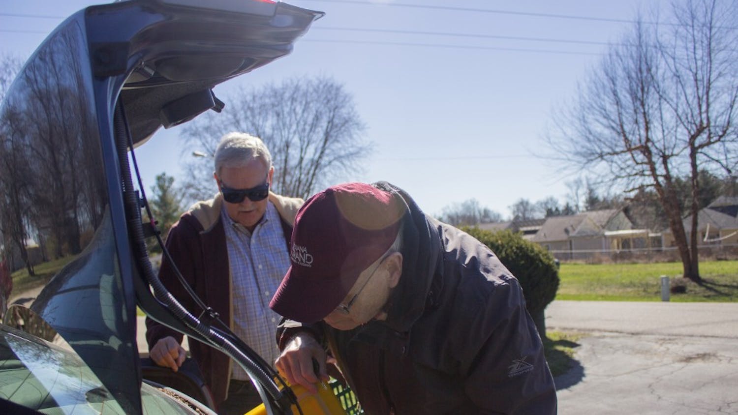 Meals on Wheels volunteers Pat Patterson and Bill Milroy retrieve a hot meal for one of their deliveries. The two men met through the program and now get together once a month to deliver meals to clients.
