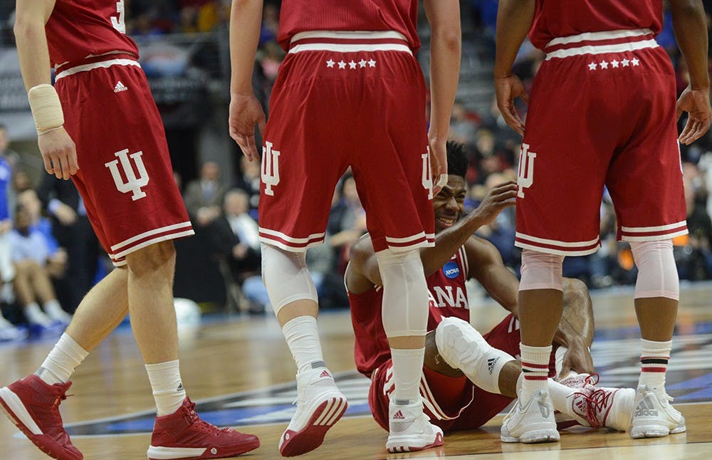Teammates gather around sophomore guard Robert Johnson during the NCAA Tournament game against Kentucky on Saturday at the Wells Fargo Arena in Des Moines, Iowa. The Hoosiers won 73-67 to advance to the Sweet 16.