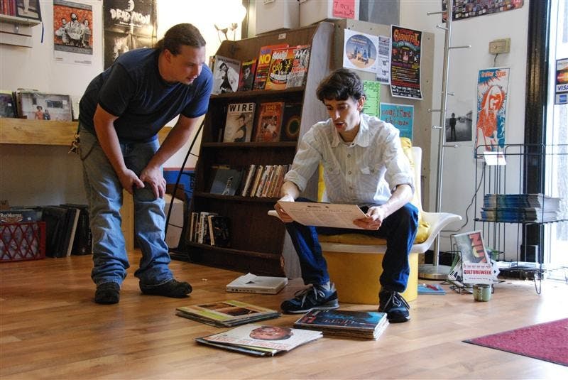 Bloomington resident Jamie Loop, 32, watches as co-owner of Landlocked Music, Jason Nickey, checks the condition of a record that Loop brought in to sell on Monday at the store. Landlocked, located just north of the Bloomington Square on North Walnut, buys, sells and trades CDs and vinyl LPs. 