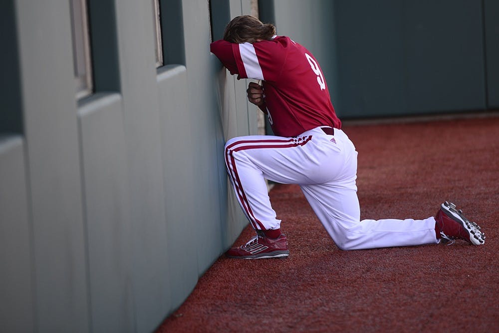 Senior infielder Casey Rodrigue kneels in prayer by the clubhouse before IU's game against Valparaiso on March 17 at Bart Kaufman Field. 