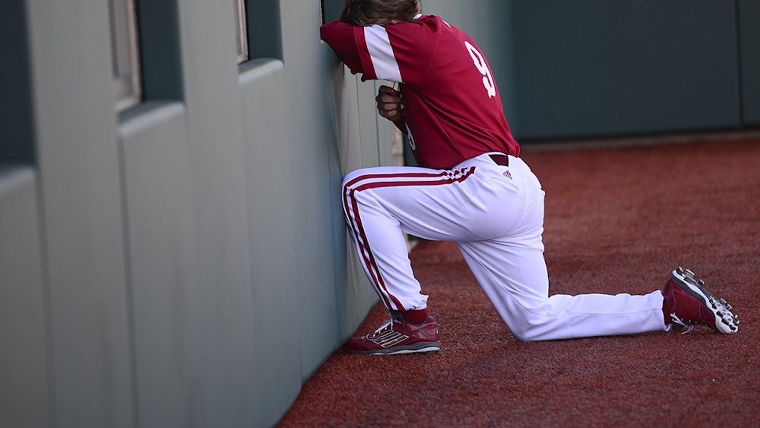 Senior infielder Casey Rodrigue kneels in prayer by the clubhouse before IU's game against Valparaiso on March 17 at Bart Kaufman Field. 