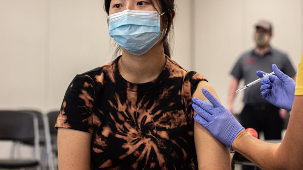 印第安纳大学大二学生Alanna Wu在印第安纳州保利的奥兰治县社区中心接受COVID-19疫苗接种。根据其疫苗接种要求，IU将接受美国食品和药物管理局(fda)批准的美国学生紧急使用疫苗，以及世界卫生组织(World Health Organization)紧急使用清单下的疫苗。