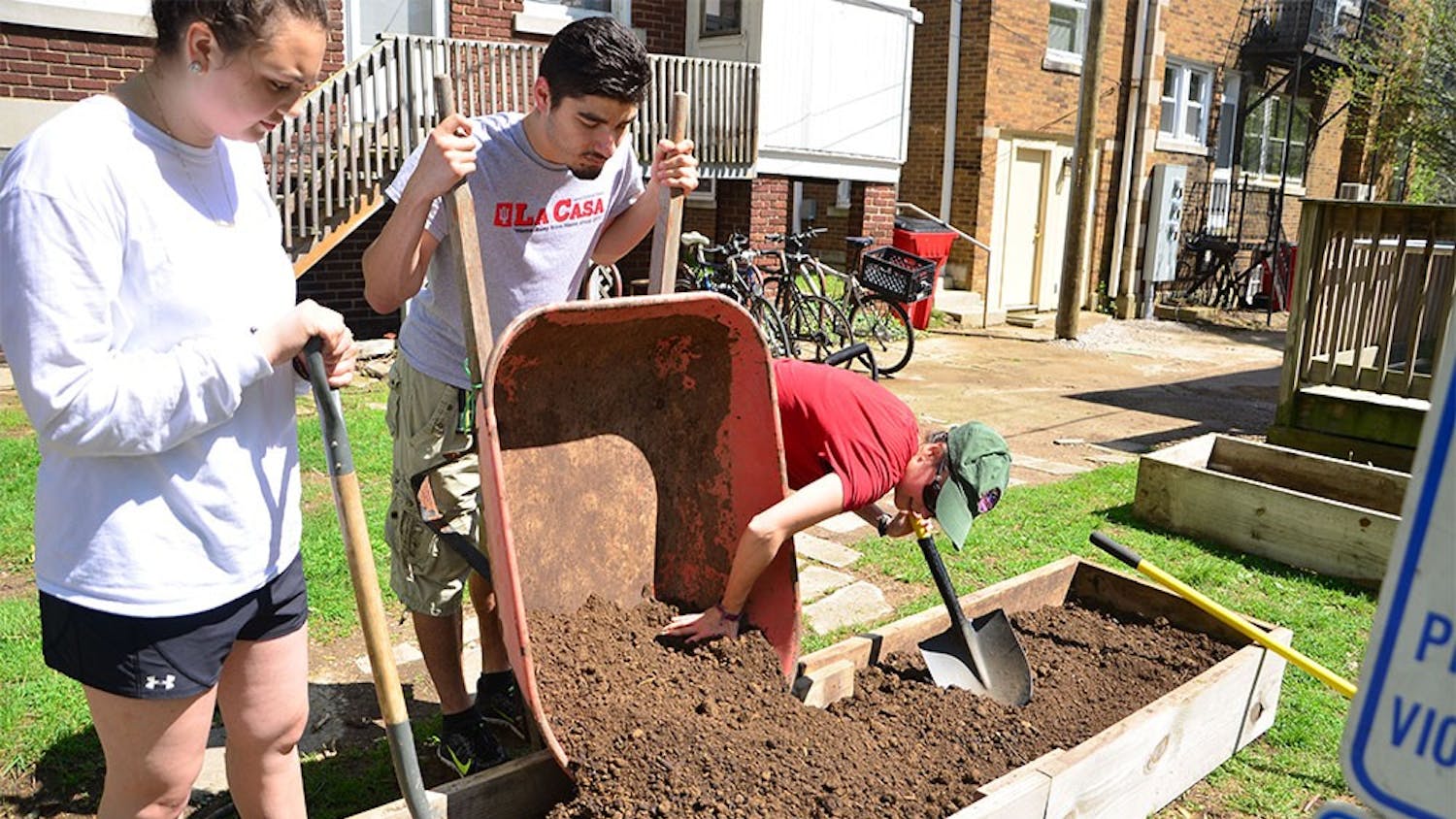 The staff of La Casa Latino Cultural Center make raised garden beds for the kitchen garden to celebrate Earth Day at the Latino Cultural Center on Friday afternoon.