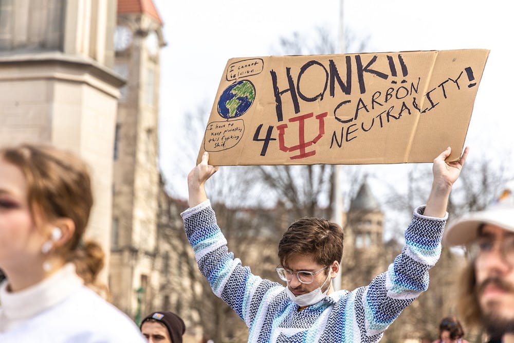 Then-junior George Schafer listens to a speaker during Students for a New Green World's protest for climate action March 4, 2022, in front of the Sample Gates.