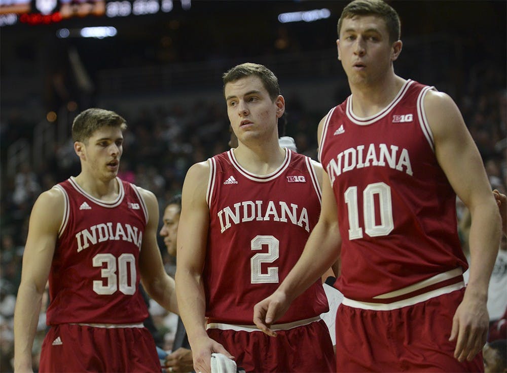 Junior forward Collin Hartman (30), redshirt senior Nick Zeisloft (2), and redshirt senior forward Ryan Burton (10) head to the bench to sit down during the game against Michigan State on Sunday at the Breslin Center in East Lansing, Michigan. The Hoosiers lost 69-88.