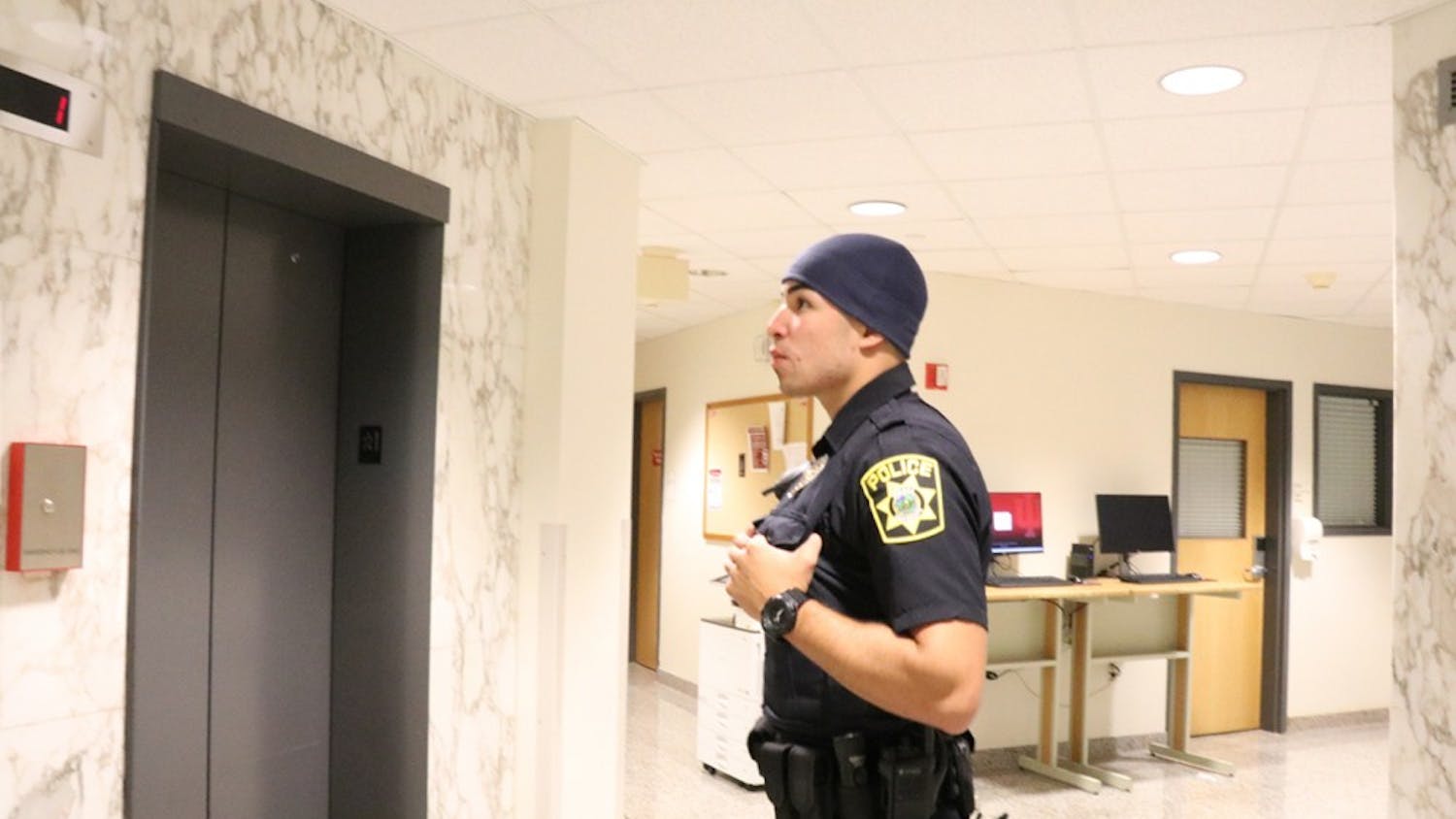 Full-time officer Pablo Padilla awaits an elevator at Willkie Residence Center. One of IUPD's most common calls involves an odor of marijuana. 
