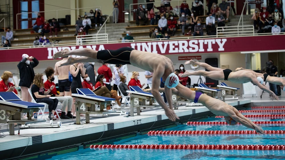 Freshman Jasper Davis jumps off the block to swim in the men&#x27;s 200-yard free race on Jan. 28, 2022, at the Counsilman Billingsley Aquatic Center. Indiana swim and dive concluded the regular season with 14 Big Ten weekly awards.