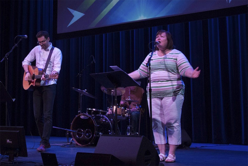Trans Jeffords, left, Julie Devine Phillips, performs Christian music on the stage Sunday morning at the Buskirk-chumley theater. This was the open-door service provided by the First United Methodist church.
