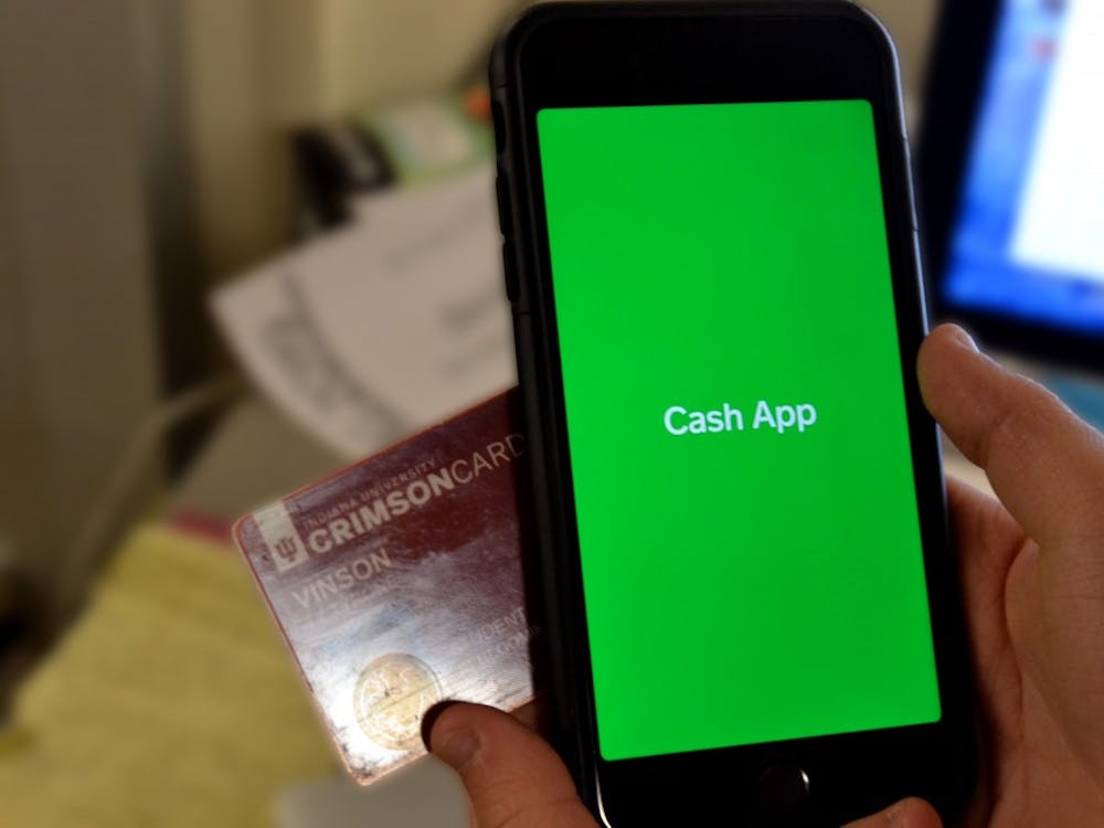 A phone with the Cash App displayed is pictured next to a Crimson Card.
