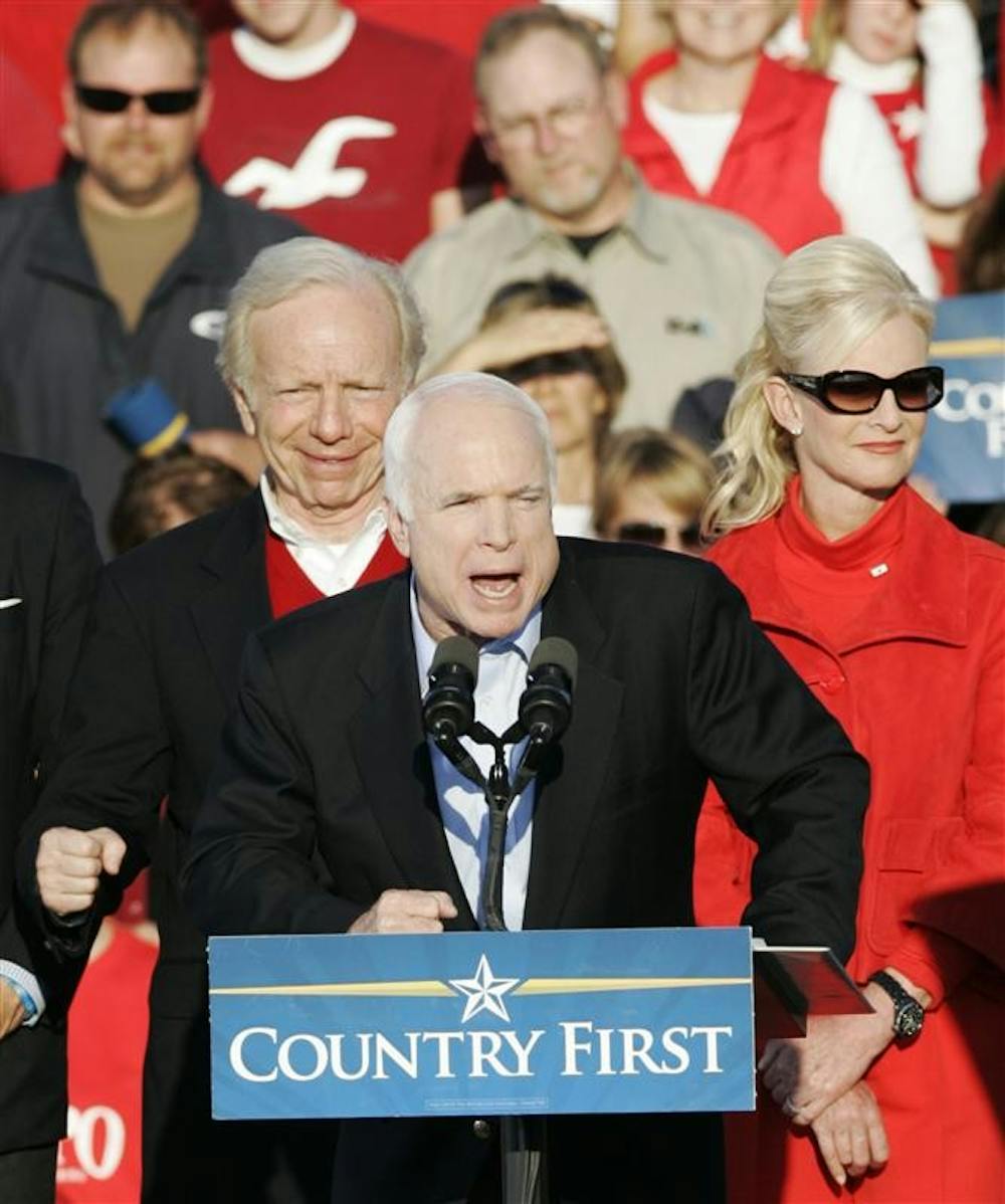 Republican presidential candidate John McCain speaks to supporters as Sen. Joe Lieberman and McCain's wife Cindy stand behind him at a rally on Monday at the Indianapolis International Airport.  McCain told the attendees that he needs their votes.