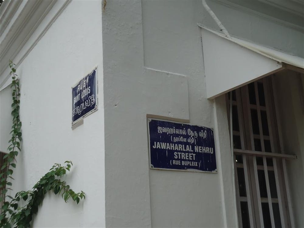 A street sign in Pondicherry, Tamil Nadu, displays the Indian and French names for a street in English, Tamil and French