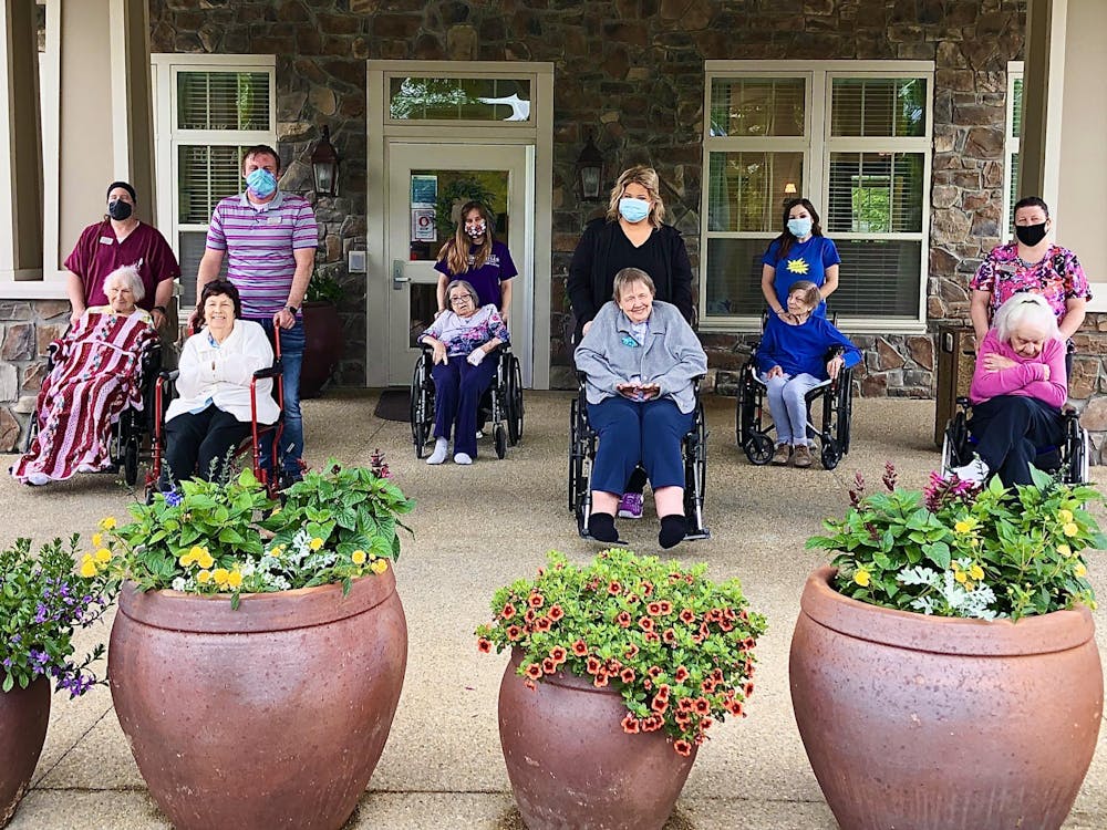 Residents of the Autumn Hills Alzheimer&#x27;s Special Care Center smile for a photo. The center received one of  14 iPads that University Information Technology Services donated to hospitals and nursing homes in Monroe County.
