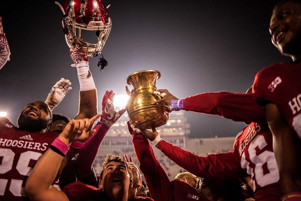 Members of the Indiana football team raise the Brass Spitoon after defeating Michigan State 24-21 in overtime Saturday night.