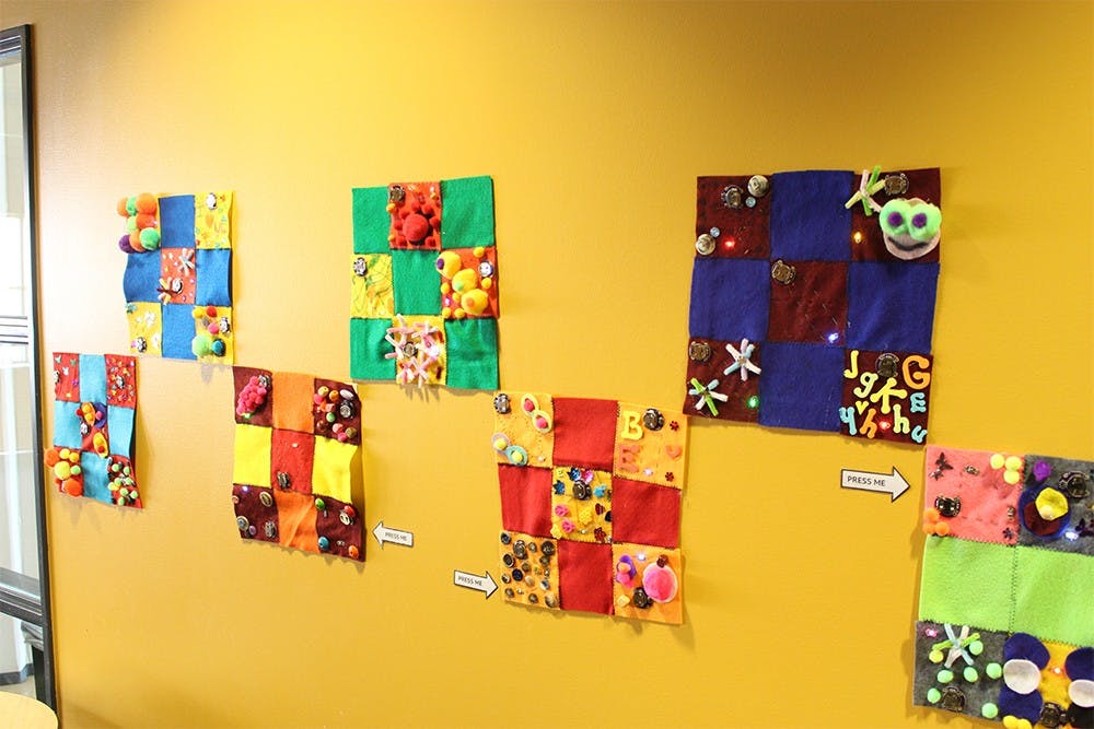 The E-Textile Community Quilt makers used fabric, conductive thread and lights to create their own patchwork pieces. They are on display in the WonderLab through March.