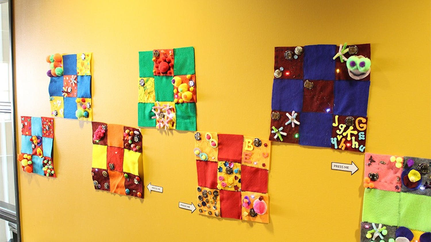 The E-Textile Community Quilt makers used fabric, conductive thread and lights to create their own patchwork pieces. They are on display in the WonderLab through March.