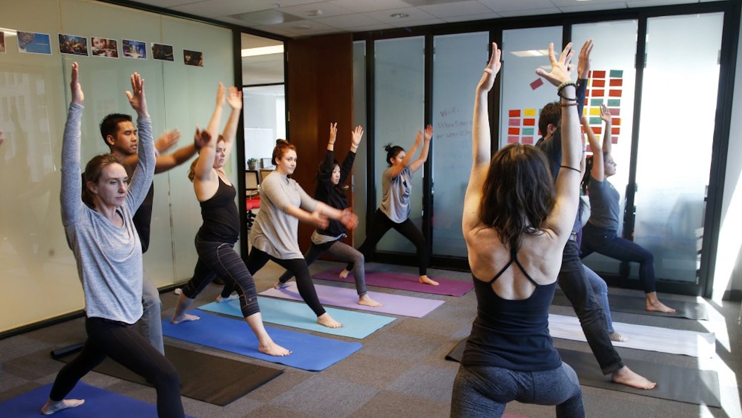 A group of people do yoga. The SRSC has yoga classes available free for students.