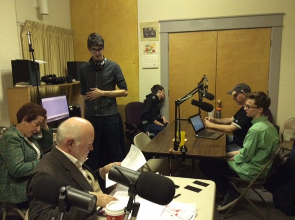 Members of the Monroe County Civic Theater prepare for a radio performance that will air on Christmas Day.