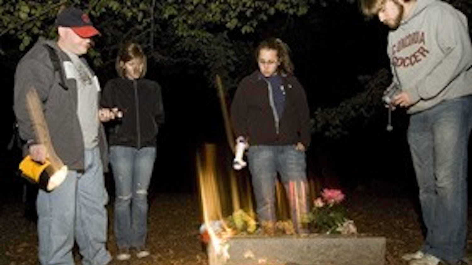 WEEKEND ghost hunters Brian J. McFillen, Allie Townsend, Sara Amato and Joe Wetzel survey a tombstone at Stepp Cemetary.  Photo by David Corso
