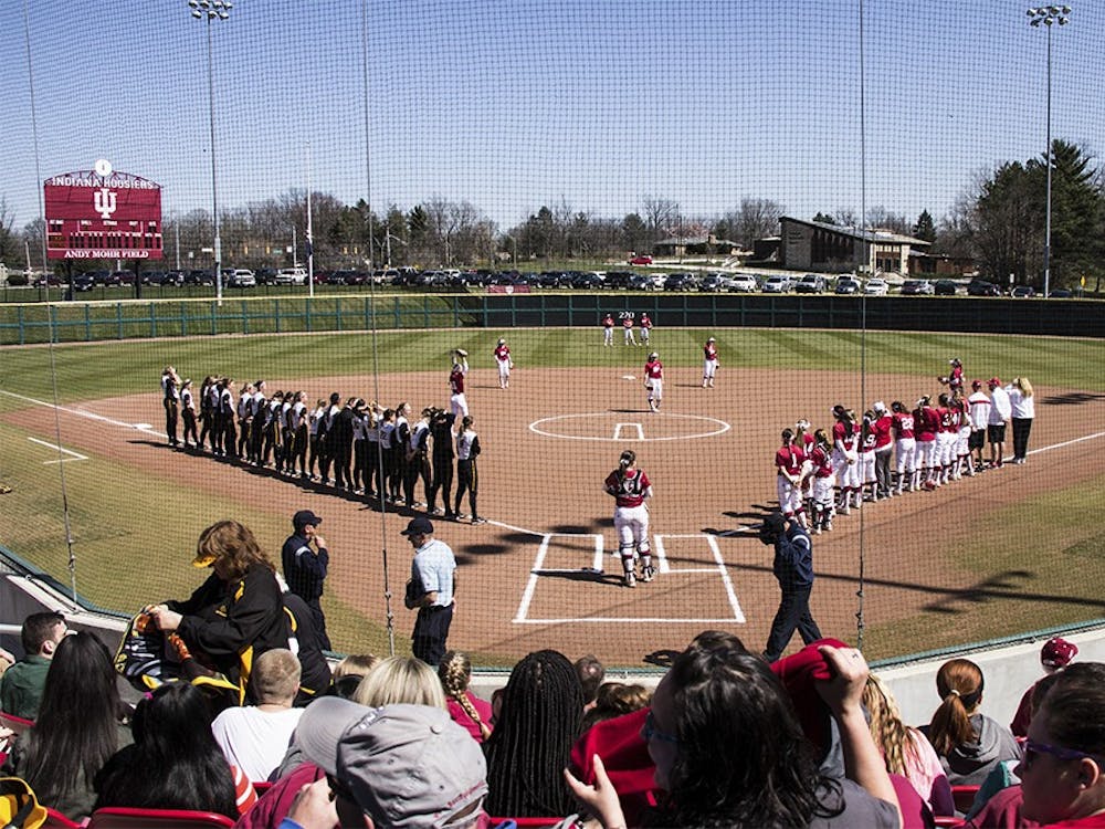 The IU and University of Iowa softball teams stand March 26, 2016, at Andy Mohr Field. The IU softball team spread #mightywithmicah on Twitter to welcome new graduate transfer Micah Schroder.