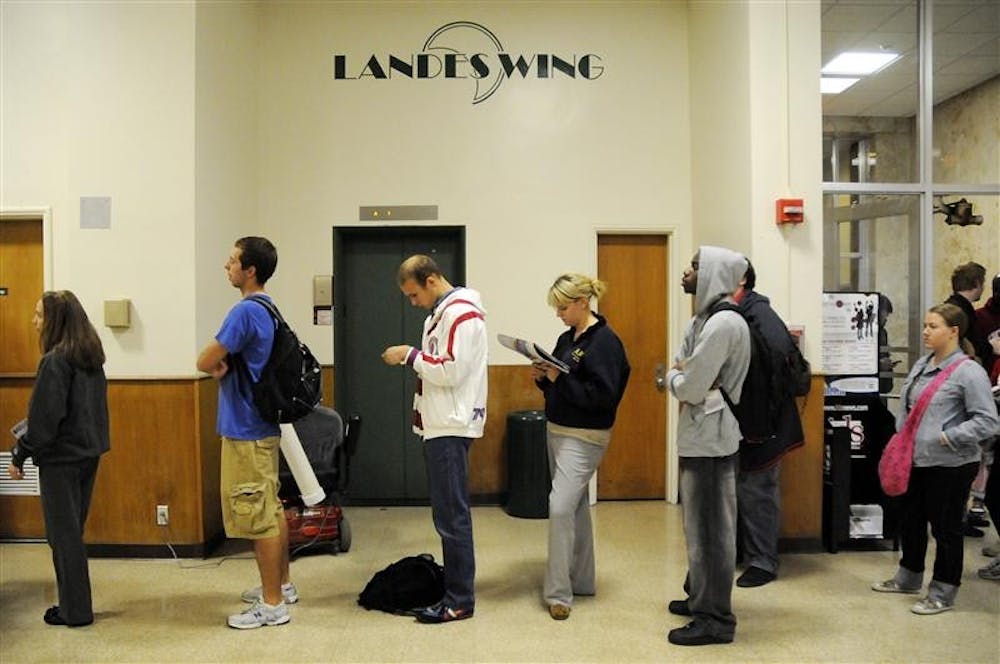 Students read newspapers, worked on homework or talked to friends while waiting in a long line to vote Tuesday morning at Read Landes. Poll workers said several people were waiting in line around 5 a.m. to vote. The polls did not open until 6 a.m.