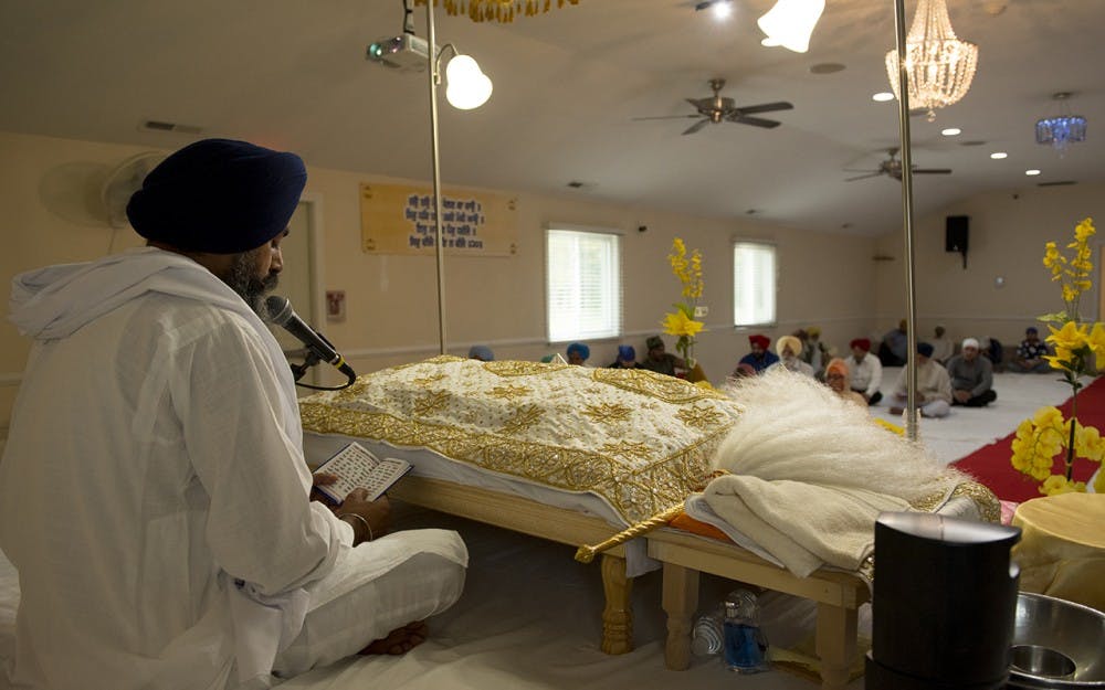 A Sikh priest reading out passages from the Guru Granth Sahib, a Holy Book, to a congregation in Fishers, Ind.