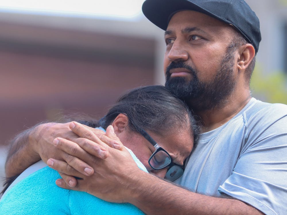 Ramandeep Chochan cries into the chest of a loved one Sunday at Monument Circle in Indianapolis. Family members of victims killed in a mass shooting Thursday said that thoughts and prayers are not enough and demanded action going forward.
