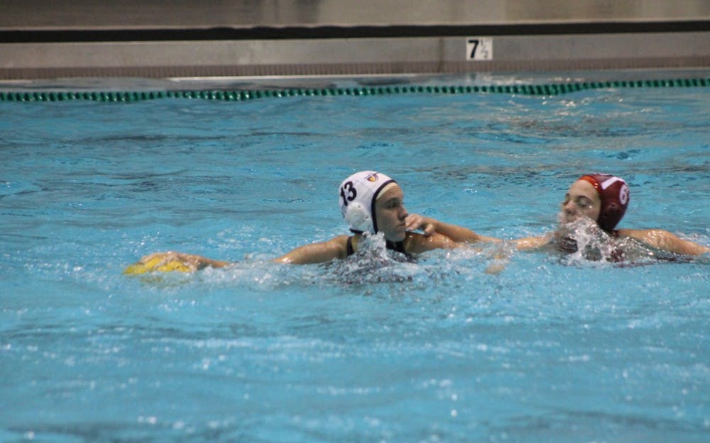 	Jessica Castellano of California Baptist University defends the ball from IU junior Jennifer Beadle on Saturday evening. The Hoosiers defeated the Lancers 13-6 in the Counsilman-Billingsley Aquatics Center.