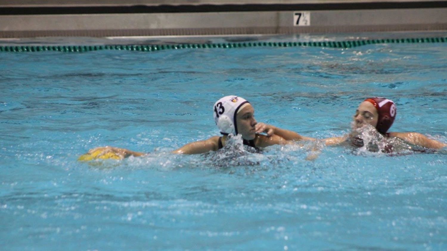 	Jessica Castellano of California Baptist University defends the ball from IU junior Jennifer Beadle on Saturday evening. The Hoosiers defeated the Lancers 13-6 in the Counsilman-Billingsley Aquatics Center.