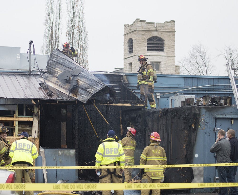 Firefighters of the Bloomington Fire Department work to remove the damaged roof of Village Deli's kitchen. The restaurant had a fire around 12 p.m. Sunday. Battalion chief Rick Petermichel said that the structure was stable.