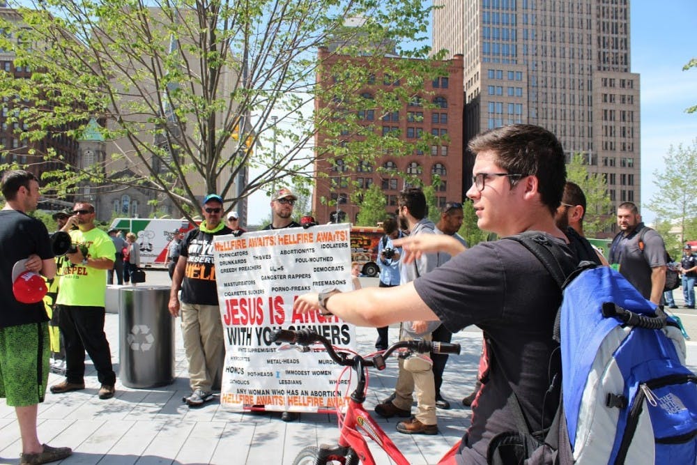 Brett Mills of Cleveland, 18, begins talking back to religious demonstrators and challenging them on their statements.