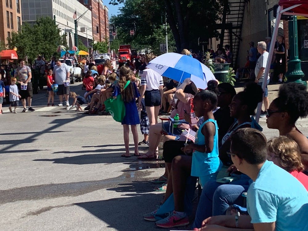 7月4日，人们聚集在门罗县法院外观看一年一度的7月4日游行。游行参与者向孩子们分发贴纸、手链、玩具、水和糖果。