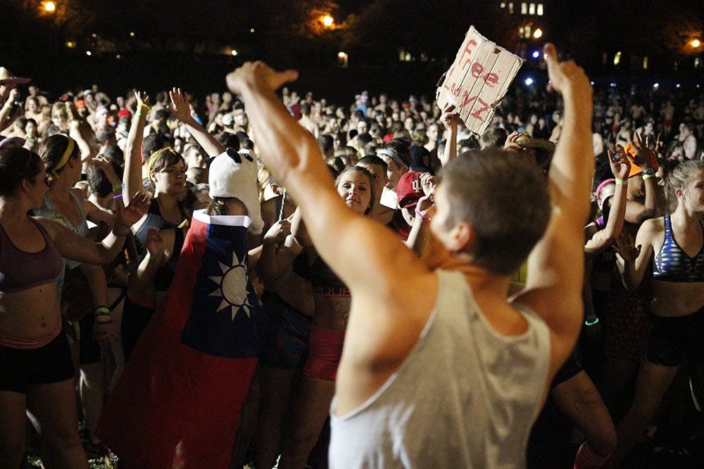 Caleb Marshall, IU Recreational Sport Instructor, dances in front of a crowd of students before the Nearly Naked Mile run Wednesday at Dunn Meadow. 