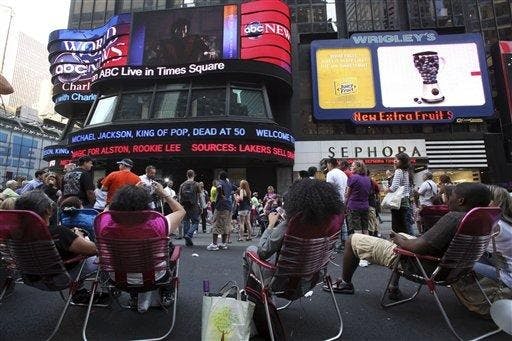 People watch the news and video about Michael Jackson in New York's Times Square, Thursday, June 25, 2009. Jackson has died at the age of 50 in Los Angeles.