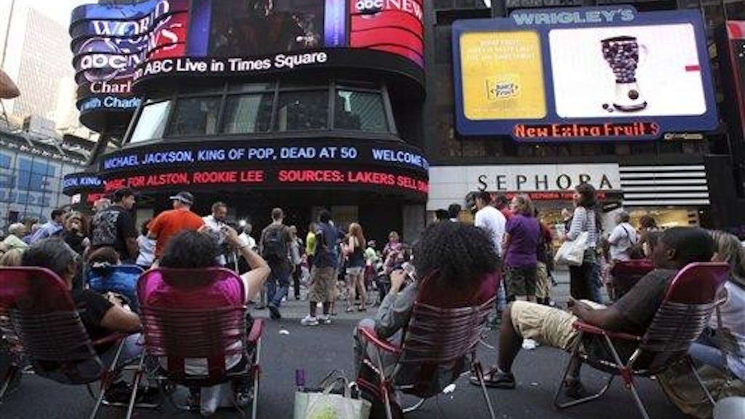 People watch the news and video about Michael Jackson in New York's Times Square, Thursday, June 25, 2009. Jackson has died at the age of 50 in Los Angeles.