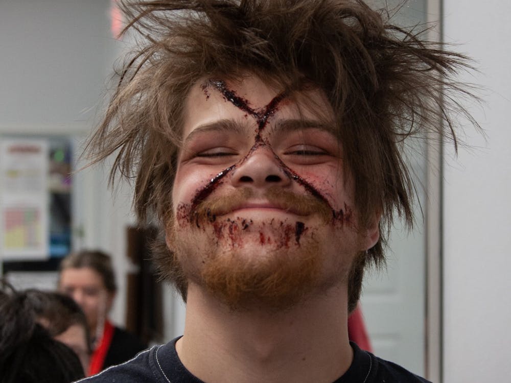 An Indy Scream Park actor shows off gory makeup and tousled hair done by Jodi Morgan, the park&#x27;s head makeup manager, before heading to scare visitors the evening of Oct. 23, 2022. Morgan used Fresh Scab, a goopy red makeup, to quickly apply fake gashes to the actor&#x27;s face.﻿
