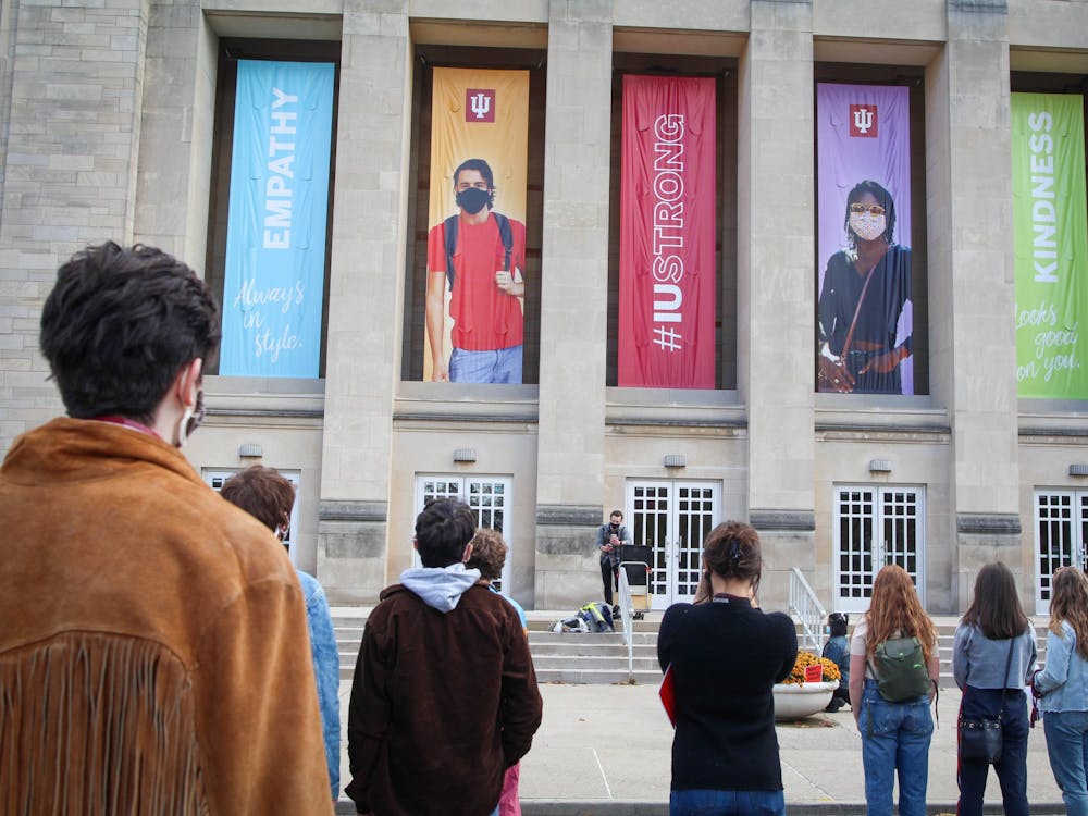 Rallygoers stand in front of the IU Auditorium on Friday afternoon. Students organized to call for IU to fire associate professor Murray McGibbon, but IU confirmed McGibbon resigned shortly before the rally began.