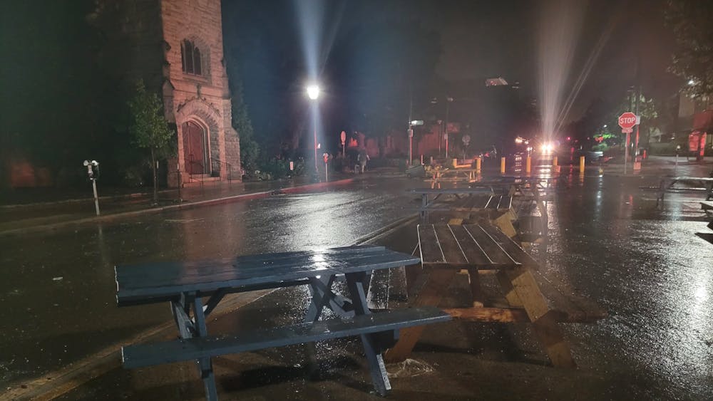 周五晚上被洪水冲走后，野餐桌躺在布卢明顿的柯克伍德大街上。周六，布卢明顿消防局副局长杰姆·瓦谢尔（Jayme Washel）就洪水安全问题和《印第安纳日报》的学生进行了交谈。