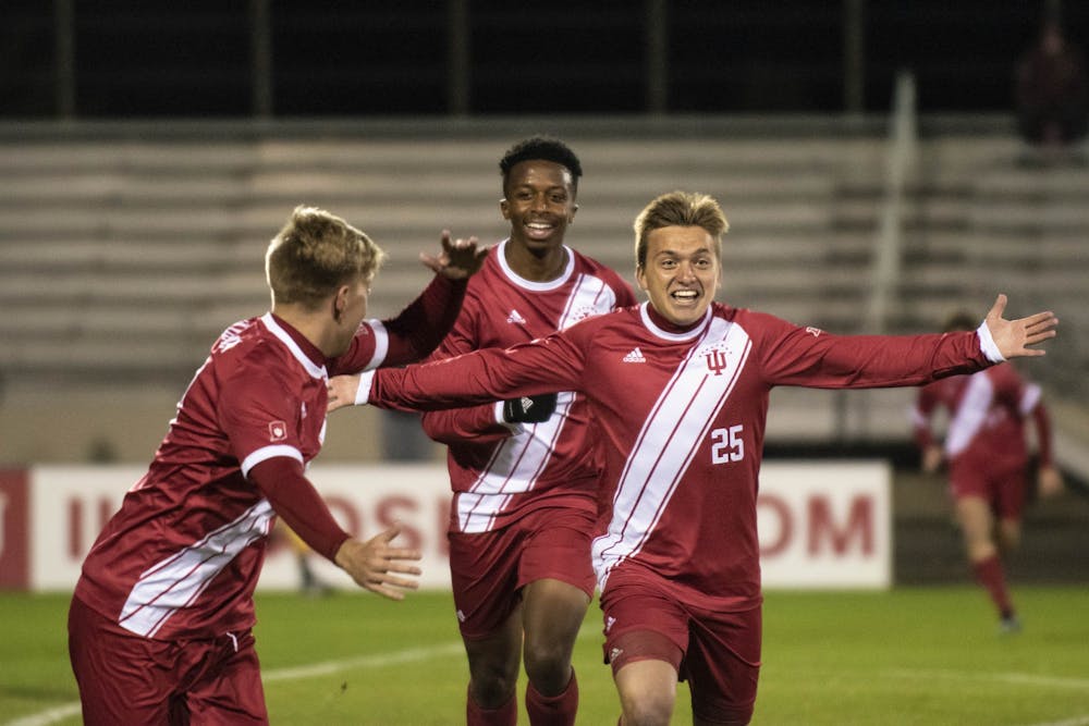 Redshirt freshman Trey Kapsalis, right, celebrates his first goal of the season with freshman Maouloune Goumballe, center, and redshirt sophomore John Bannec, left, on Oct. 22 at Bill Armstrong Stadium. IU beat Maryland 1-0 off of a goal in the second overtime period.