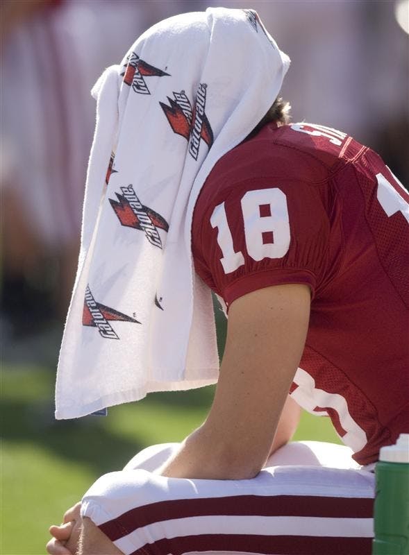 Senior kicker Austin Starr sits on the bench with a towel draped over his head before the start of the game against Central Michigan at on Saturday on Memorial Stadium. Starr missed his only field goal attempt in the 37-34 loss to the Chippewas.