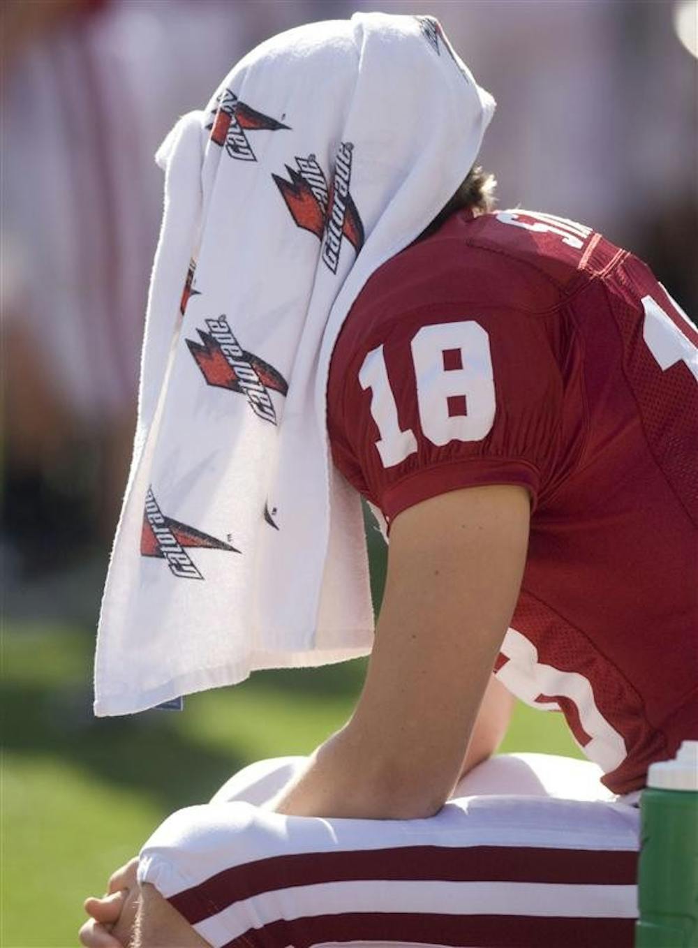 Senior kicker Austin Starr sits on the bench with a towel draped over his head before the start of the game against Central Michigan at on Saturday on Memorial Stadium. Starr missed his only field goal attempt in the 37-34 loss to the Chippewas.