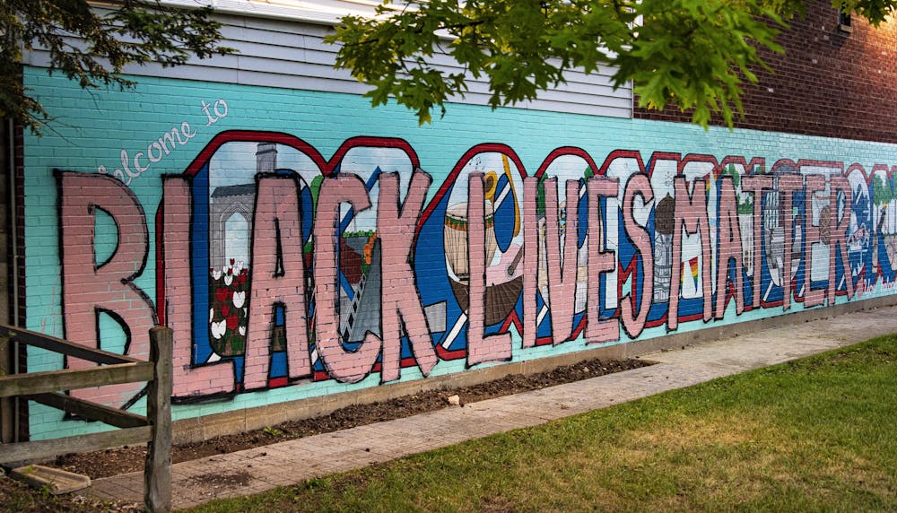 <p>Lights shine July 13 on the mural in Peoples Park. &quot;Black lives matter&quot; was painted over the mural following the killing of George Floyd by Minneapolis police in May.</p>