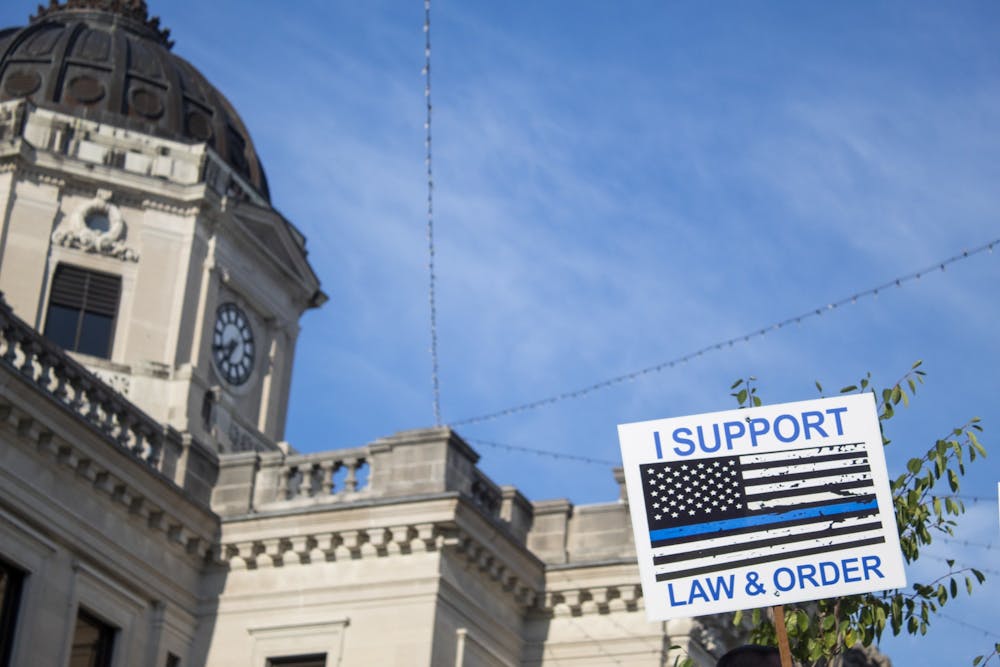 <p>A sign reading “I support law &amp; order” is held up Aug. 22 in front of the Monroe County Courthouse. During the protest there were several altercations between pro-police and Black Lives Matter groups. </p>