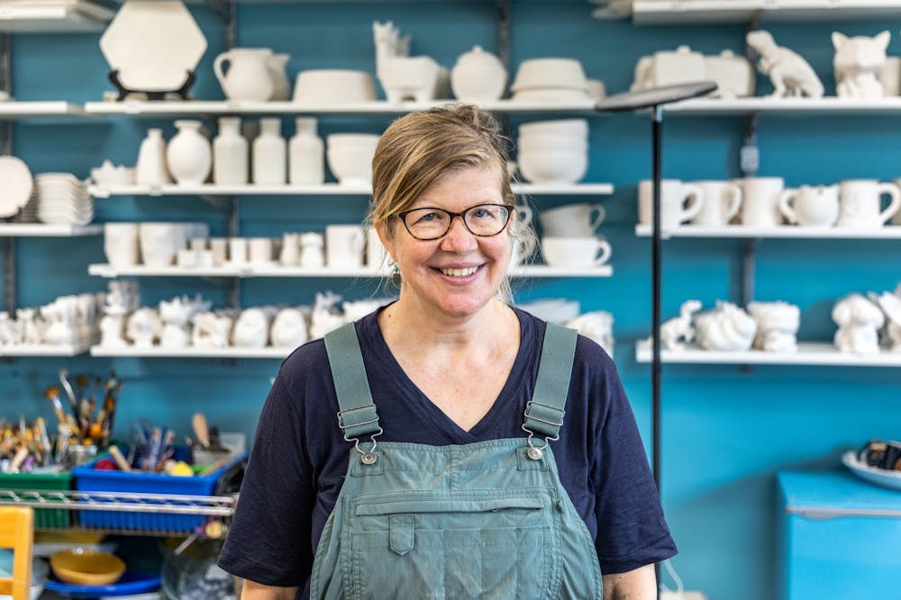 苏珊斯奈德，陶瓷馆工作室所有者，在她的业务内部姿势9月4日，2021年。斯奈德在学习意大利陶器后开设了布卢明顿的工作室。