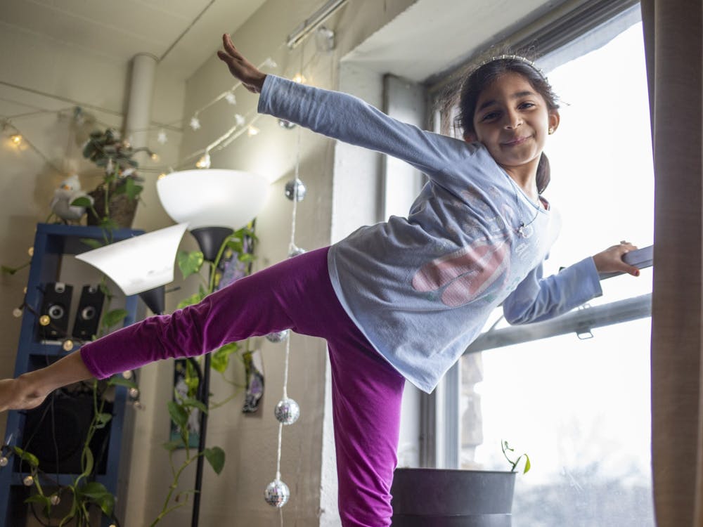 Arwa, 7, poses after peaking trough the window of her apartment in Redbud Hill on April 9, 2022. Her father, Ihab Mohamed, says Arwa was the first person in the family to make friends with their neighbors. The building she and her family live in is slated for demolition over the summer. 