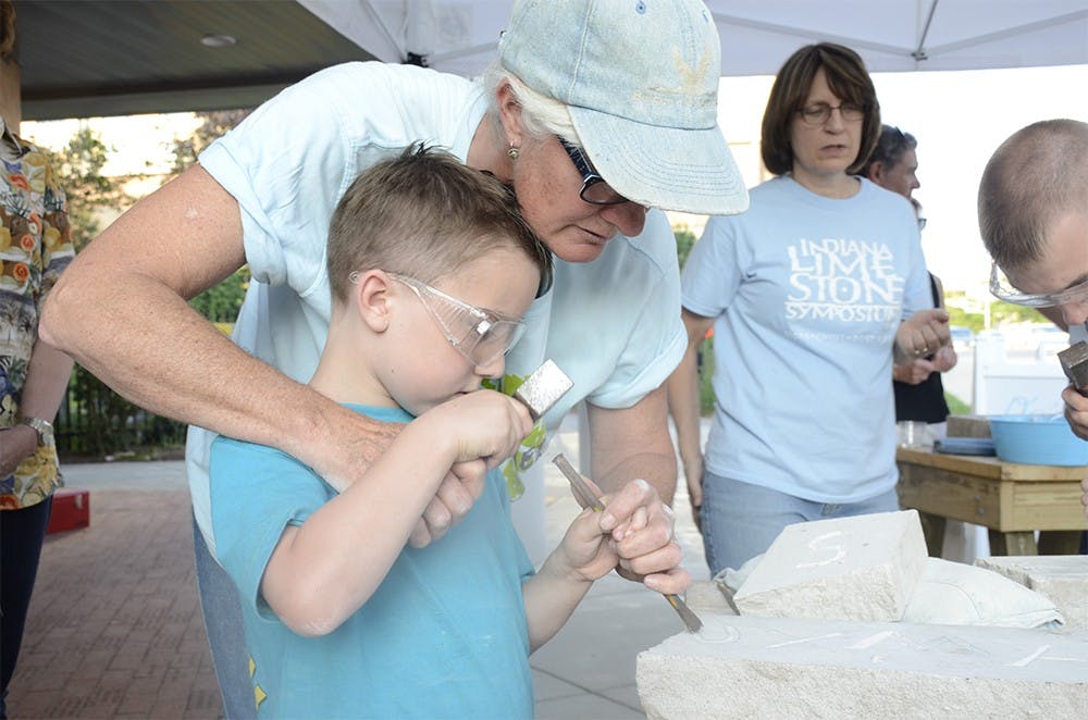 Sharon Fullingim, artist from the Indiana Limestone Symposium, teaches an event participant how to carve limestone at the WonderLab Museum of Science, Health and Technology on Friday. The carving event was part of the celebration of the Limestone Month, which was created in 2007.