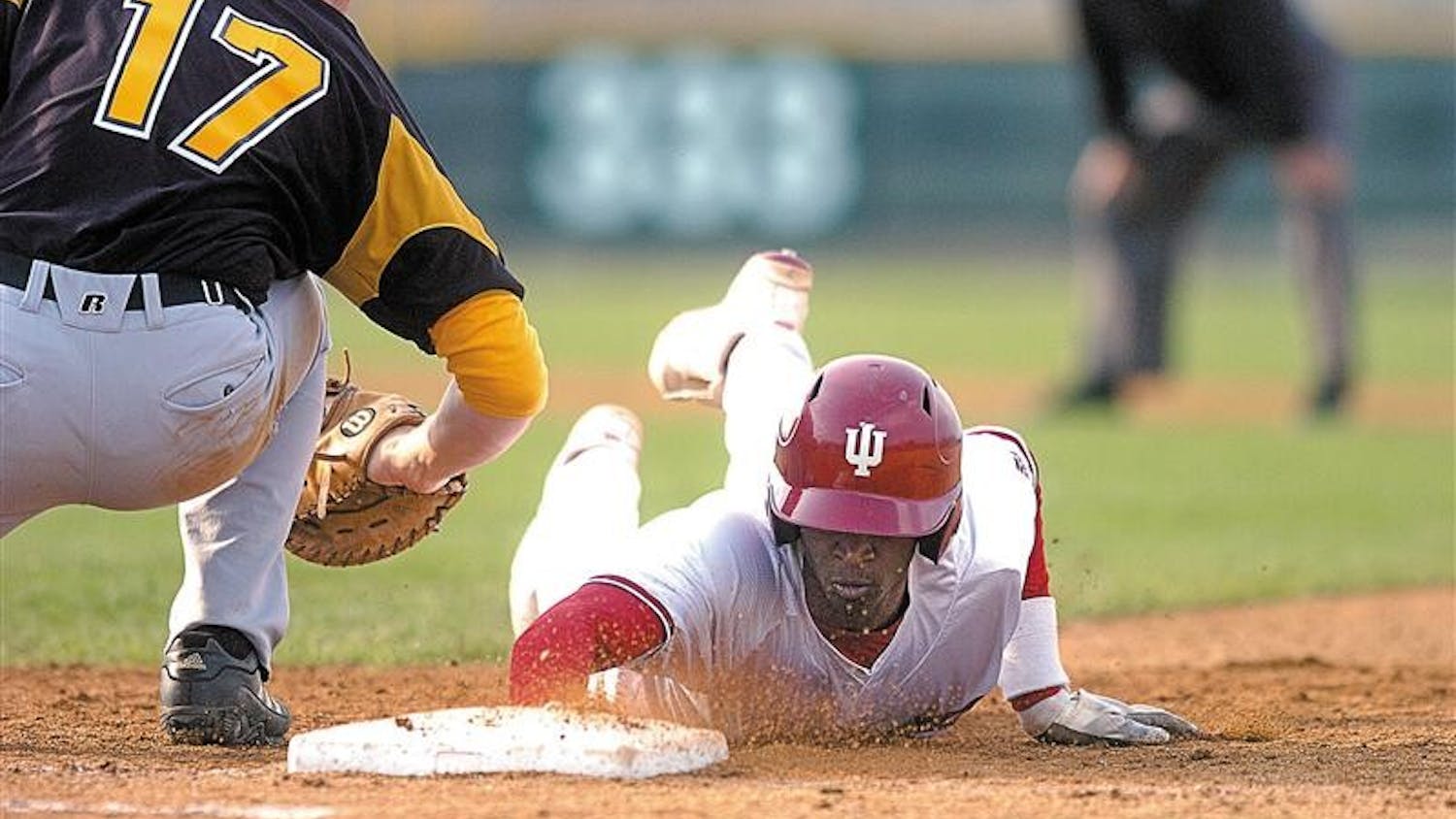 Junior outfielder Evan Crawford dives back to first base after Valparaiso's Ryan O'Gara tries to apply a tag on a pickoff play. Crawford had two hits in the 9-5 Hoosier win.